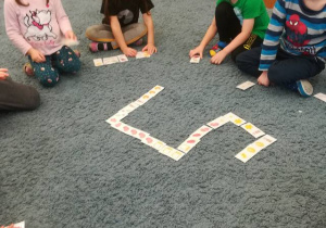 Grupa dzieci gra w wielkanocne domino.
